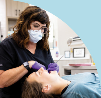 Image of a dental technician cleaning a patients teeth | Dental Support provided by SDB